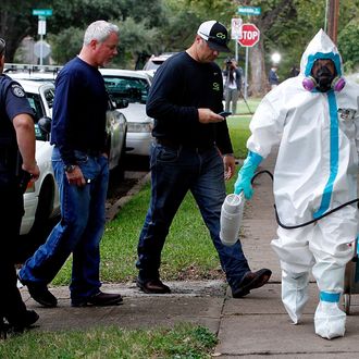 DALLAS, TX - OCTOBER 12: A man dressed in protective hazmat clothing leaves after treating the front porch and sidewalk of an apartment where a second person diagnosed with the Ebola virus resides on October 12, 2014 in Dallas, Texas. A female nurse working at Texas Heath Presbyterian Hospital, the same facility that treated Thomas Eric Duncan, has tested positive for the virus. (Photo by Mike Stone/Getty Images)