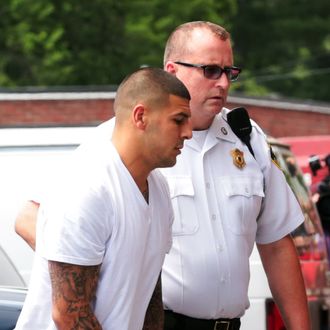 Former New England Patriots tight end AARON HERNANDEZ wears handcuffs as he is escorted into Attleboro District Court on Wednesday. Hernandez has not been ruled out as a suspect in the death of semi-pro football player, 27-year-old Odin Lloyd who was found shot dead near the home of Hernandez.