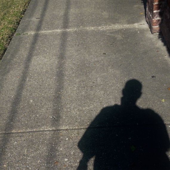 The shadow of a teenage boy on a sidewalk.