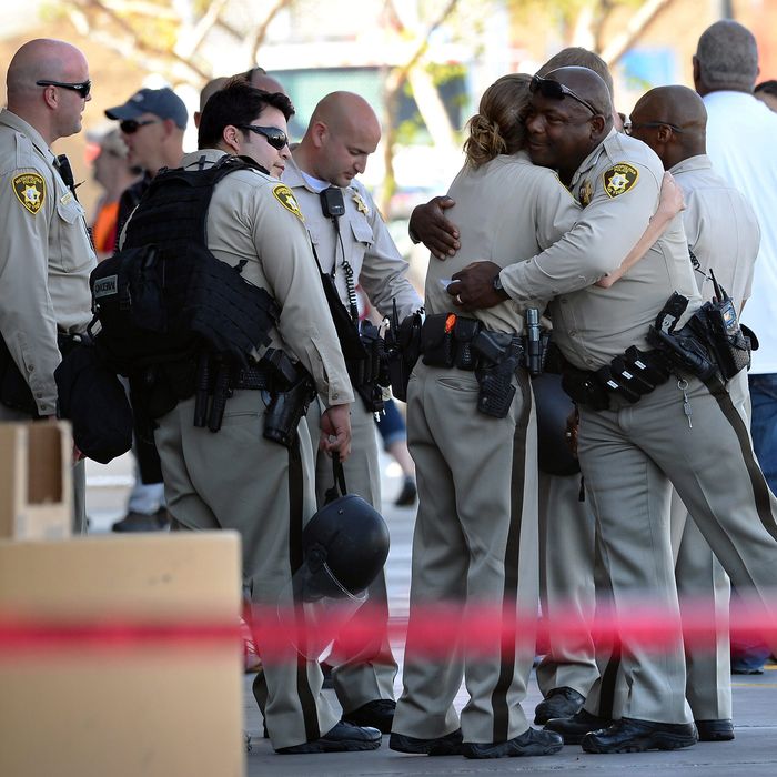 Las Vegas Metropolitan Police Department officers hug near a Wal-Mart on June 8, 2014 in Las Vegas, Nevada. Two officers were reported shot and killed by two assailants at a pizza restaurant near the Wal-Mart. The two suspects then reportedly went into the Wal-Mart where they killed a third person before killing themselves. 