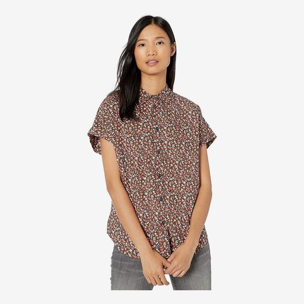 A model wearing the button down high collar Goodthreads Women’s Lightweight Cotton Short-Sleeve Shirt with loose sleeves in a small floral print. 33 Things on Sale You’ll Actually Want to Buy: From Adidas to Le Creuset - The Strategist