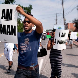 Aaron Coleman, left, joins other protesters marching on Florissant Road in historic downtown Ferguson, Mo., Monday, Aug. 11, 2014. The group marched along the closed street, rallying in front of the town's police headquarters to protest the shooting of 18-year-old Michael Brown by Ferguson police officers. Brown, who was killed in a confrontation with police in the St. Louis suburb, was shot Saturday, Aug. 9, 2014, and died following the confrontation with police. (AP Photo/Sid Hastings)