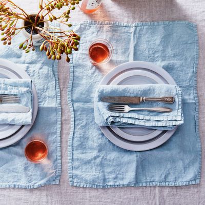 Blue linen napkins and placemats at a table setting — The Strategist reviews all the best linen to buy right now.