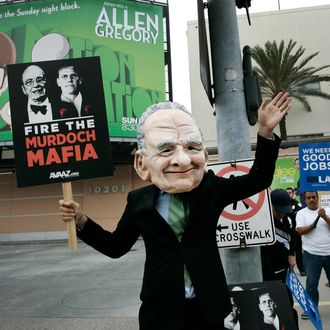 A demonstrator wearing a Rupert Murdoch mask protests outside of Fox Studios during News Corp.'s annual shareholders meeting in Los Angeles, California, U.S., on Friday, Oct. 21, 2011. News Corp. investors challenged Chairman Rupert Murdoch and his sons at the media company's annual meeting, demanding governance changes and an end to voting practices that cement family control. Photographer: Jonathan Alcorn/Bloomberg via Getty Images