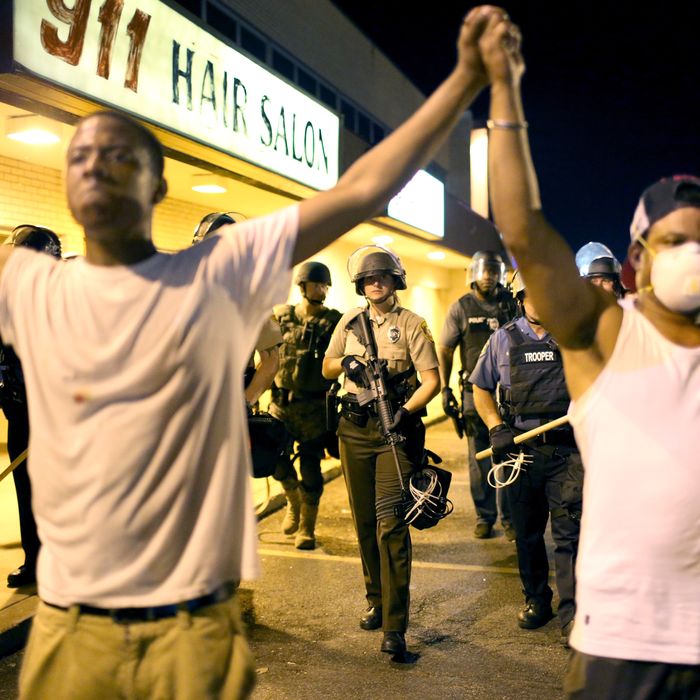 FERGUSON, MO - AUGUST 19: Protesters are pushed back by police on August 19, 2014 in Ferguson, Missouri. Violent outbreaks have taken place in Ferguson since the shooting death of unarmed teenager Michael Brown by a Ferguson police officer on August 9th. (Photo by Joe Raedle/Getty Images)