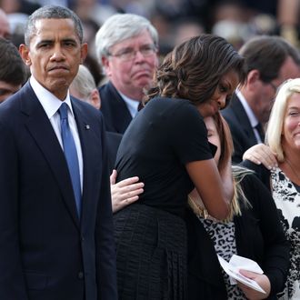 WASHINGTON, DC - SEPTEMBER 22: U.S. President Barack Obama (L) pauses as first lady Michelle Obama hugs a family membr during a memorial service for victims of the Washington Navy Yard shooting at the Marine Barracks September 22, 2013 in Washington, DC. The president and first lady Michelle Obama (2nd L) visited with families of the victims in the deadly shooting at the Washington Navy Yard. Thirteen people, including the gunman Aaron Alexis, were killed in the incident. (Photo by Alex Wong/Getty Images)