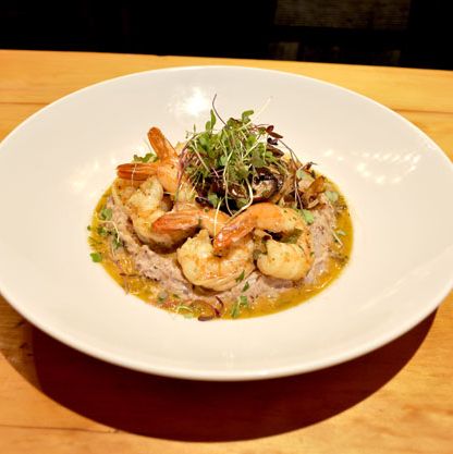 Shrimp and grits with Anson Mills grits, tasso ham, and sautéed mushrooms.