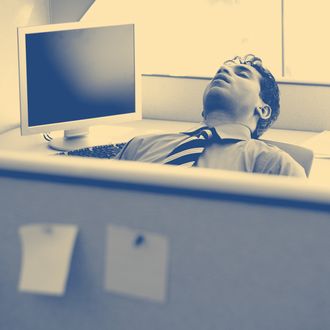 Businessman sleeping in cubicle