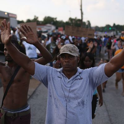 FERGUSON, MO - AUGUST 18: Demonstrators protesting the shooting death of Michael Brown chant, 