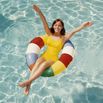 Woman relaxing in pool float tossing beach ball