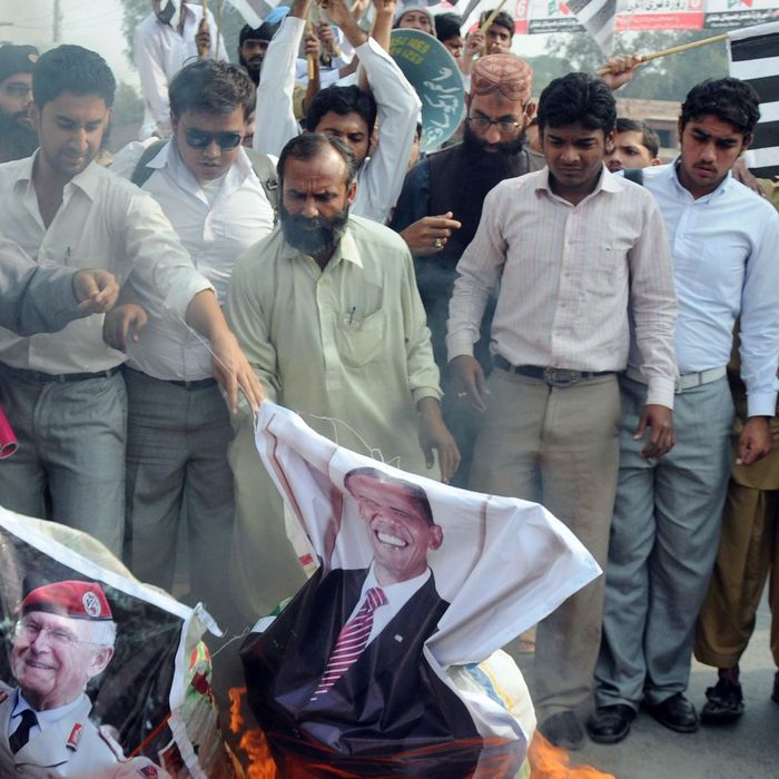 Supporters of Pakistan's outlawed Islamic hardliner Jamaat ud Dawa (JD) burn an effigy of the US President Barack Obama, NATO and US flags during a protest in Multan on November 28, 2011, against a NATO strike on Pakistan troops. Hundreds of Pakistanis called on Islamabad to break off its alliance with the United States and get out of the war on Al-Qaeda as protests against a lethal NATO strike pushed into a third day. Twenty-four Pakistani soldiers were killed in the cross-border attack early Saturday by NATO helicopters and fighter jets. AFP PHOTO / S.S MIRZA (Photo credit should read S.S MIRZA/AFP/Getty Images)