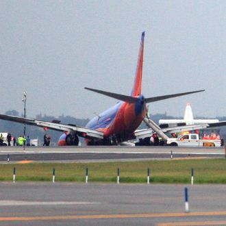 NEW YORK - JULY 22: (EDITORS NOTE: Retransmission with alternate crop.) A Southwest Airlines flight remains on runway 4 after the plane's landing gear collapsed shortly after touching down on the runway, at LaGuardia Airport in the Queens borough of New York City. The flight, which originated in Nashville, landed at 5:45 p.m. and was carrying 149 passengers and crew. A reported 10 people were injured. (Photo by Andy Jacobsohn/Getty Images)