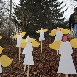 Eric Mueller places twenty seven wooden angles he made in his yard down the street from the Sandy Hook School December 16, 2012 in Newtown, Connecticut. Twenty-six people were shot dead, including twenty children, after a gunman identified as Adam Lanza opened fire at Sandy Hook Elementary School.