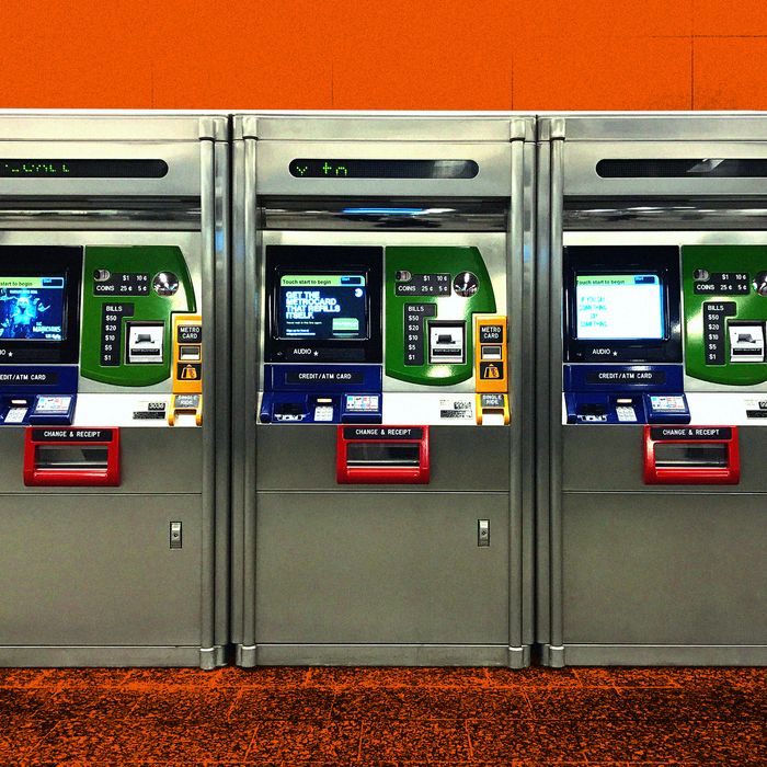 A row of four MetroCard machines in a row against an orange tinted background