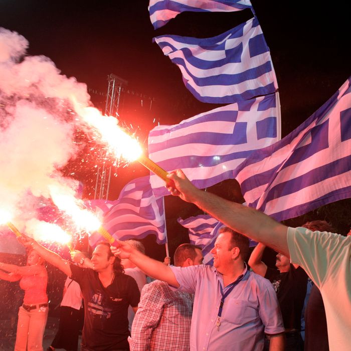 ATHENS, GREECE - JUNE 15: Supporters of the 'New Democracy' political party light flares during a rally ahead of Sunday's general election on June 15, 2012 in Athens, Greece. The Greek electorate are due to go to the polls in a re-run of the general election on June 17, 2012 after no combination of political parties were able to form a coalition government. Recent opinion polls have placed the anti-bailout party 'Syriza' equal in popularity with the pro-bailout 'New Democracy' ahead of Sunday's general election which could determine whether Greece retains the Euro as its currency.(Photo by Milos Bicanski/Getty Images)