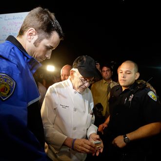 Homeless advocate Arnold Abbott, 90, of the nonprofit group Love Thy Neighbor Inc., center, gets his drivers license to hand to a Fort Lauderdale police officer, Wednesday, Nov. 5, 2014, in Fort Lauderdale, Fla. Abbott and a group of volunteers were feeding the homeless in a public parking lot next to the beach when he was issued a summons to appear in court for violating an ordinance that limits where charitable groups can feed the homeless on public property. Abbott w also recently arrested along with two pastors for feeding the homeless in a Fort Lauderdale park. (AP Photo/Lynne Sladky)