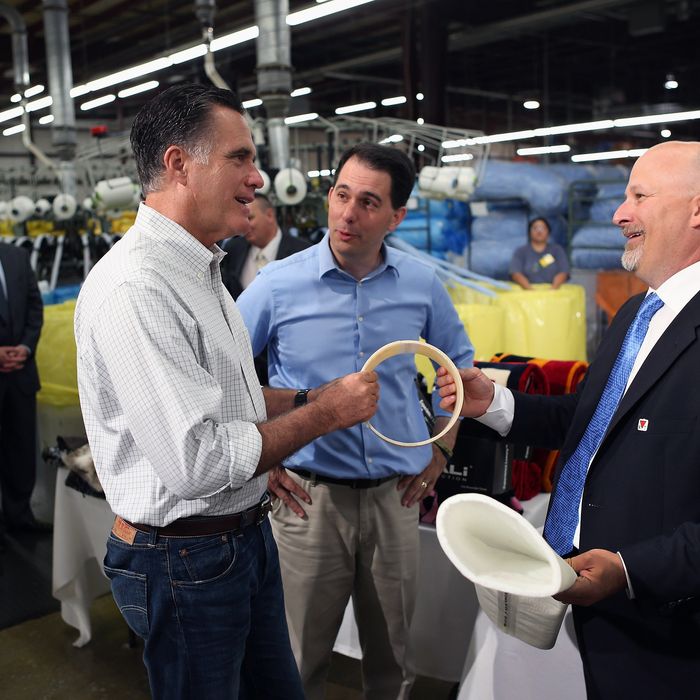 Republican presidential candidate, former Massachusetts Gov. Mitt Romney (L) and Wisconsin Governor Scott Walker (C), listen as Dan Sinykin, president of Monterey Mills, shows them products made at the factory on June 18, 2012 in Janesville, Wisconsin. Mr. Romney continues hs campaign swing through battle ground states as he battles President Barack Obama for votes. 