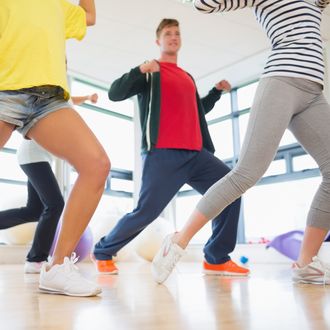 Fitness class and instructor doing pilates exercise