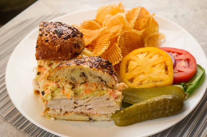 The Jewish Boy From Queens: roasted turkey on an onion pocket with sliced tomatoes, greens, Marilyn&#8217;s coleslaw, and Russian dressing, with sliced pickles and onions.