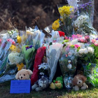 Offerings are left at a curbside shrine as residents pay tribute to the victims of an elementary school shooting in Newtown, Connecticut, on December 15, 2012. A young gunman slaughtered 20 small children and six teachers on December 14 after walking into a school in an idyllic Connecticut town wielding at least two sophisticated firearms.