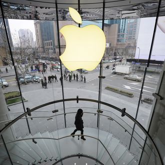 A customer walks under an Apple logo sign at an Apple shop in Shanghai on February 22, 2012. Despite suffering a setback in a Shanghai court on February 23, Proview Technology, a financially strapped Chinese company has reportedly opened up a US front in its legal war with Apple over the iPad trademark. AFP PHOTO / Peter PARKS (Photo credit should read PETER PARKS/AFP/Getty Images)