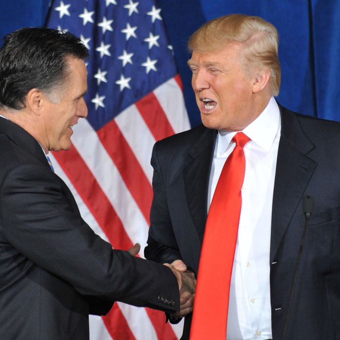 Businessman Donald Trump (R) shakes hands with Republican presidential hopeful Mitt Romney