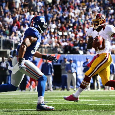 Quarterback Robert Griffin III #10 of the Washington Redskins avoids a tackle by outside linebacker Michael Boley #59 of the New York Giants during their game at MetLife Stadium on October 21, 2012 in East Rutherford, New Jersey.