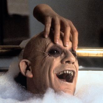 The Thing rubbing Christopher Lloyd's head in the bathtub in a scene from the film 'Addams Family Values', 1993.