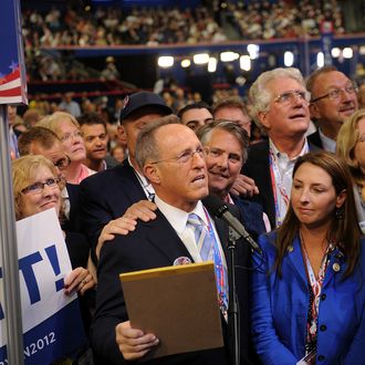 Scott Romney, brother of Republican presidential candidate Mitt Romney, center, announces Michigan's choice for presidential candidate while Ronna Romney McDaniel, committeewoman for the Michigan Republican Party, center right, listens at the Republican National Convention (RNC) in Tampa, Florida, U.S., on Tuesday, Aug. 28, 2012. Delegates are gathered in Tampa at the 40th Republican National Convention to select former Massachusetts governor Mitt Romney as their nominee for the next president of the United States.