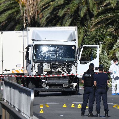 Forensics officers and policemen look for evidences near a truck on the Promenade des Anglais seafront in the French Riviera town of Nice on July 15, 2016, after it drove into a crowd watching a fireworks display.