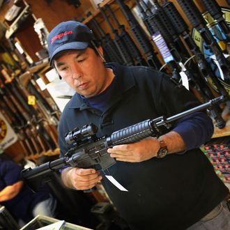 Jason Zielinski shows a customer an AR-15 style rifle at Freddie Bear Sports sporting goods store on December 17, 2012 in Tinley Park, Illinois. 