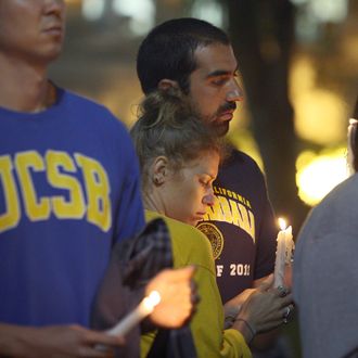 LOS ANGELES , CA - MAY 26: Students of UCSB and UCLA mourn at a candlelight vigil at UCLA for the victims of a killing rampage over the weekend near UCSB on May 26, 2014 in Los Angeles, California. According to reports, 22 year old Elliot Rodger, son of assistant director of the Hunger Games, Peter Rodger, began his mass killing near the University of California, Santa Barbara by stabbing three people to death in an apartment. He then went on to shooting and running down people while driving his BMW until crashing with a self-inflicted gunshot wound to the head. Officers found three legally-purchased guns registered to him inside the vehicle. Prior to the murders, Rodger posted YouTube videos declaring his intention to annihilate the girls who rejected him sexually and others in retaliation for his remaining a virgin at age 22. Seven people died, including Rodger, and seven others were wounded. (Photo by David McNew/Getty Images)