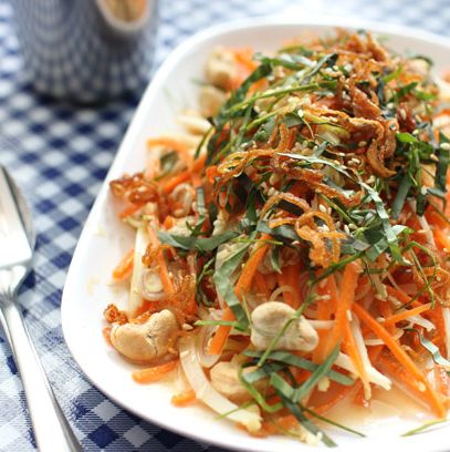 Northern Thai herbal salad with carrot, parsnip, white turmeric, betel leaf, basil, lime leaf, sawtooth, fried shallots, cashews, peanuts, dried shrimp, ground pork, and Thai chilies in a mild coconut milk dressing.