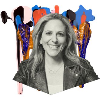 A blonde woman wearing a leather jacket smiles for a portrait.