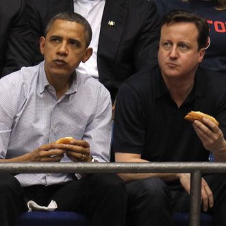 DAYTON, OH - MARCH 13: U.S. President Barack Obama (L) and British Prime Minister David Cameron (R) eat a hot dog as they watch the first half at UD Arena as the Western Kentucky Hilltoppers take on the Mississippi Valley State Delta Devils in the first round of the 2011 NCAA men's basketball tournament on March 13, 2012 in Dayton, Ohio. (Photo by Gregory Shamus/Getty Images)