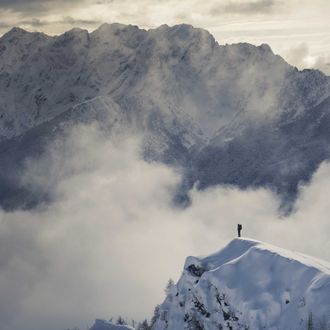 Lone climber standing on a snowy peak