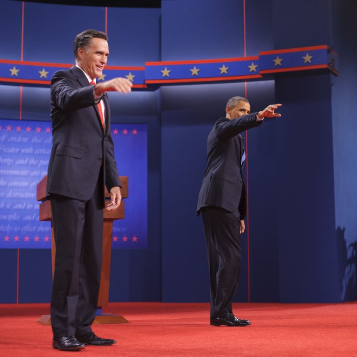 US President Barack Obama and Republican presidential candidate Mitt Romney wave October 3, 2012 after shaking hands as he arrives on stage for the first presidential debate at the University of Denver in Denver, Colorado. 