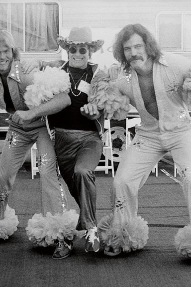 Elton having some fun with two costumed security guards.