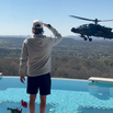 Kid Rock saluting an Army helicopter hovering near his pool