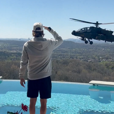 Kid Rock saluting an Army helicopter hovering near his pool