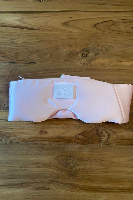A pink sleep mask on a table.