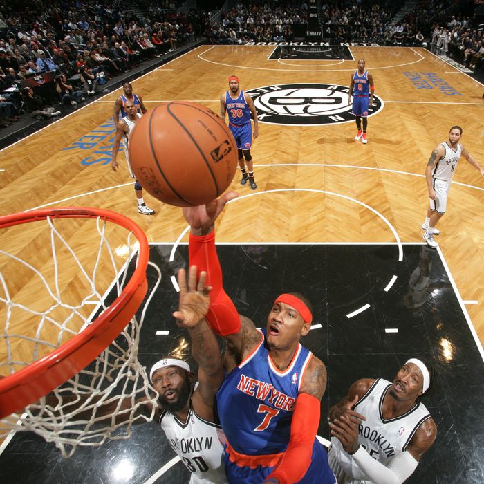 Carmelo Anthony #7 of the New York Knicks shoots against Reggie Evans #30 and Gerald Wallace #45 of the Brooklyn on Nets December 11, 2012 at the Barclays Center in the Brooklyn borough of New York City.