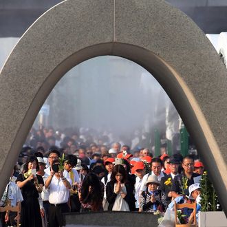 People offer prayers before a memorial monument during the 70th memorial service for the A-bomb victims at the Peace Memorial Park in Hiroshima on August 6, 2015. 