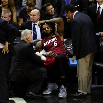 LeBron James #6 of the Miami Heat sits on the bench after leaving the game in the fourth quarter with cramps against the San Antonio Spurs during Game One of the 2014 NBA Finals at the AT&T Center on June 5, 2014 in San Antonio, Texas. 