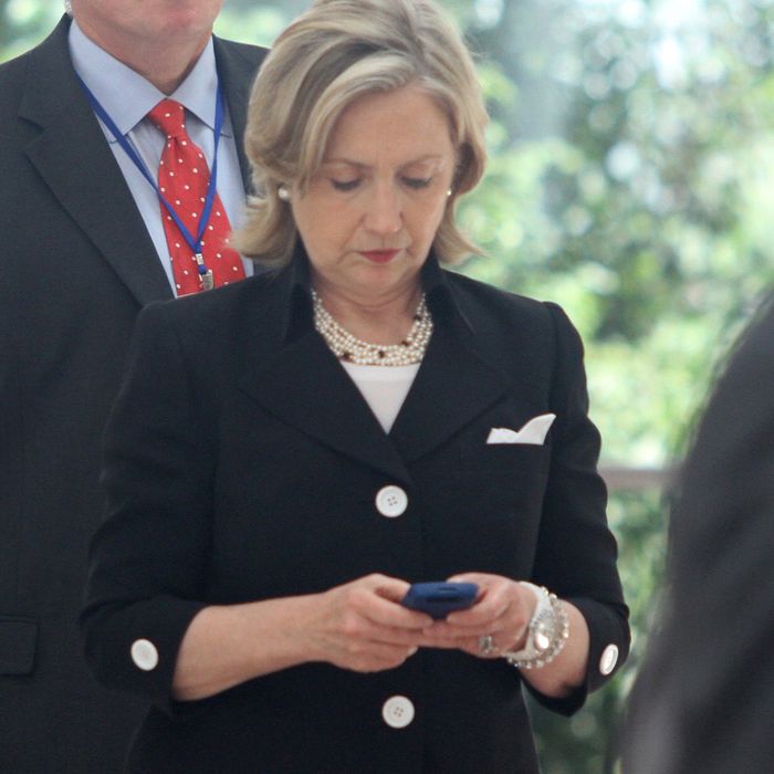 US secretary of state Hillary Clinton (C) looks at her mobile phone after attending a Russia - US meeting on the sidelines of the 43rd annual Association of South East Asian Nations (ASEAN) Ministering Meeting in Hanoi on July 23, 2010. 