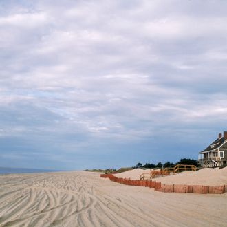 A grey shingle cottage sits on a dune overlooking a sandy beach in the Hamptons, Long Island, New York, September 1984. (Photo by Susan Wood/Getty Images)