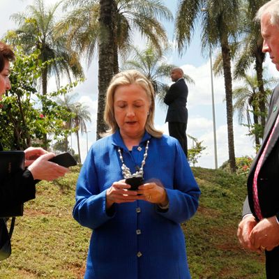 US Secretary of State Hillary Rodham Clinton (C) writes on her cell phone with Roberta S. Jacobson (L), US Assistant Secretary of State for Western Hemisphere Affairs, and US Ambassador to Brazil Thomas Shannon (R) in Brasilia, Brazil, before heading to Brussels on Tuesday April 17, 2012. AFP Photo / Pool / Jacquelyn MARTIN (Photo credit should read JACQUELYN MARTIN/AFP/Getty Images)