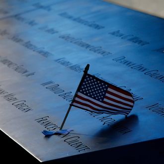 NEW YORK - SEPTEMBER 11: An American flag is stuck in a plaque of names of the victims of the September 11 attacks at the North Pool memorial during observances for the eleventh anniversary of the terrorist attacks on lower Manhattan at the World Trade Center site September 11, 2012 in New York City. The nation is commemorating the eleventh anniversary of the September 11, 2001 attacks which resulted in the deaths of nearly 3,000 people after two hijacked planes crashed into the World Trade Center, one into the Pentagon in Arlington, Virginia and one crash landed in Shanksville, Pennsylvania. (Photo by Mike Segar-Pool/Getty Images)