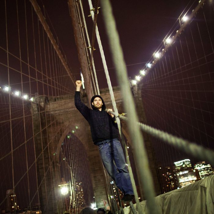 NEW YORK, NY - NOVEMBER 17: A protestor affiliated with the Occupy Wall Street Movement raises his fist in the air while chanting on the Brooklyn Bridge in New York City on November 17, 2011. The day has been marked by sporadic violence, arrests, and injuries sustained by both protestors and police. Protestors marched around Wall Street throughout the morning, attempting to disrupt businesses from operating. (Photo by Andrew Burton/Getty Images)