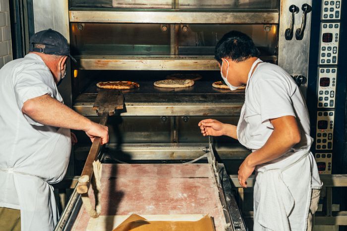 Josh Eden和Breads主面包师达尔文Castillo在大炉前工作